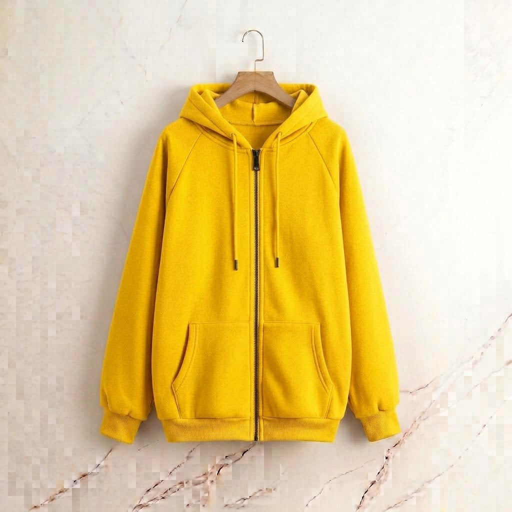 A bright yellow zip-up hoodie with a drawstring hood and front pockets, hanging on a wooden hanger against a light textured wall.