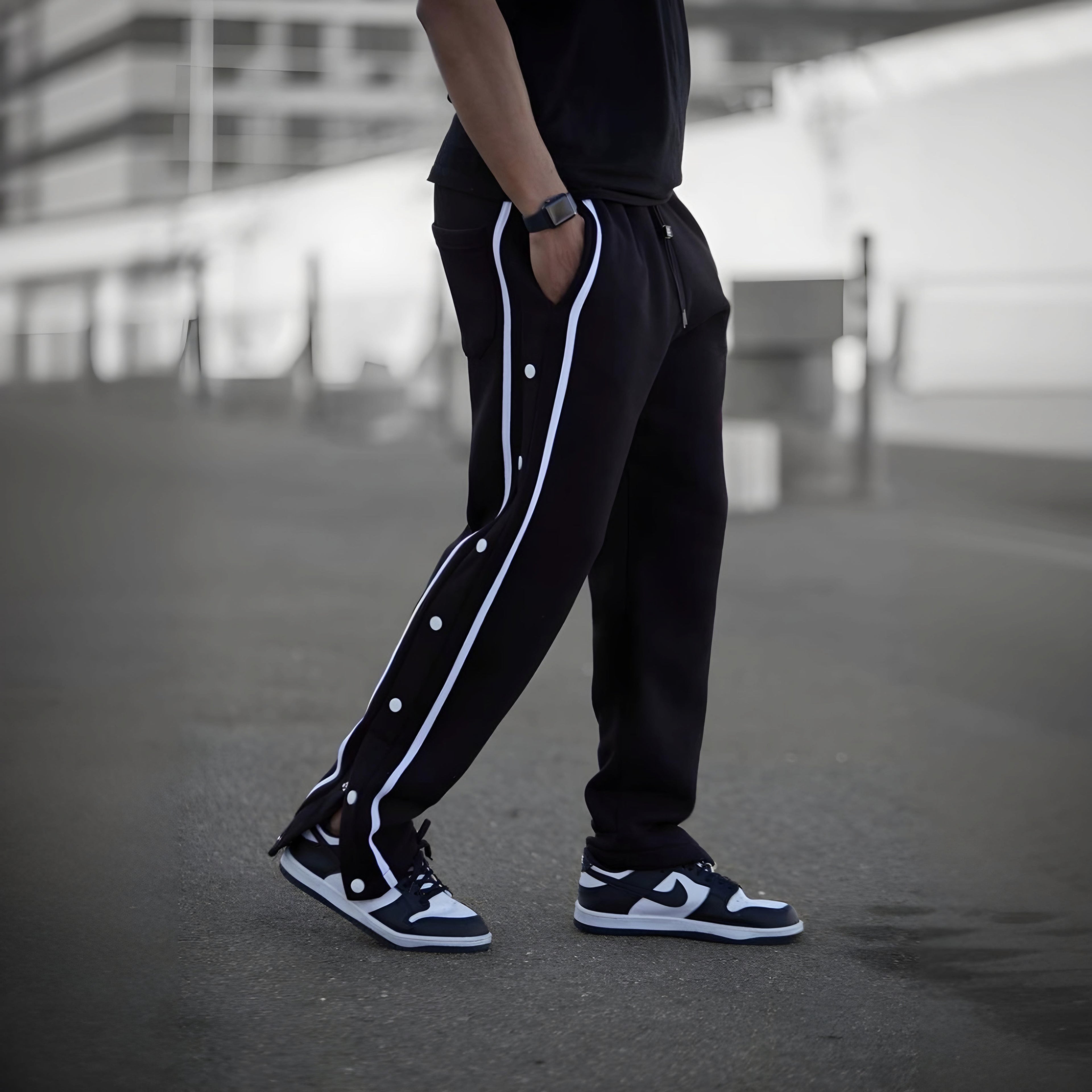 Black varsity pants with white side stripes and snap buttons - men's streetwear track pants