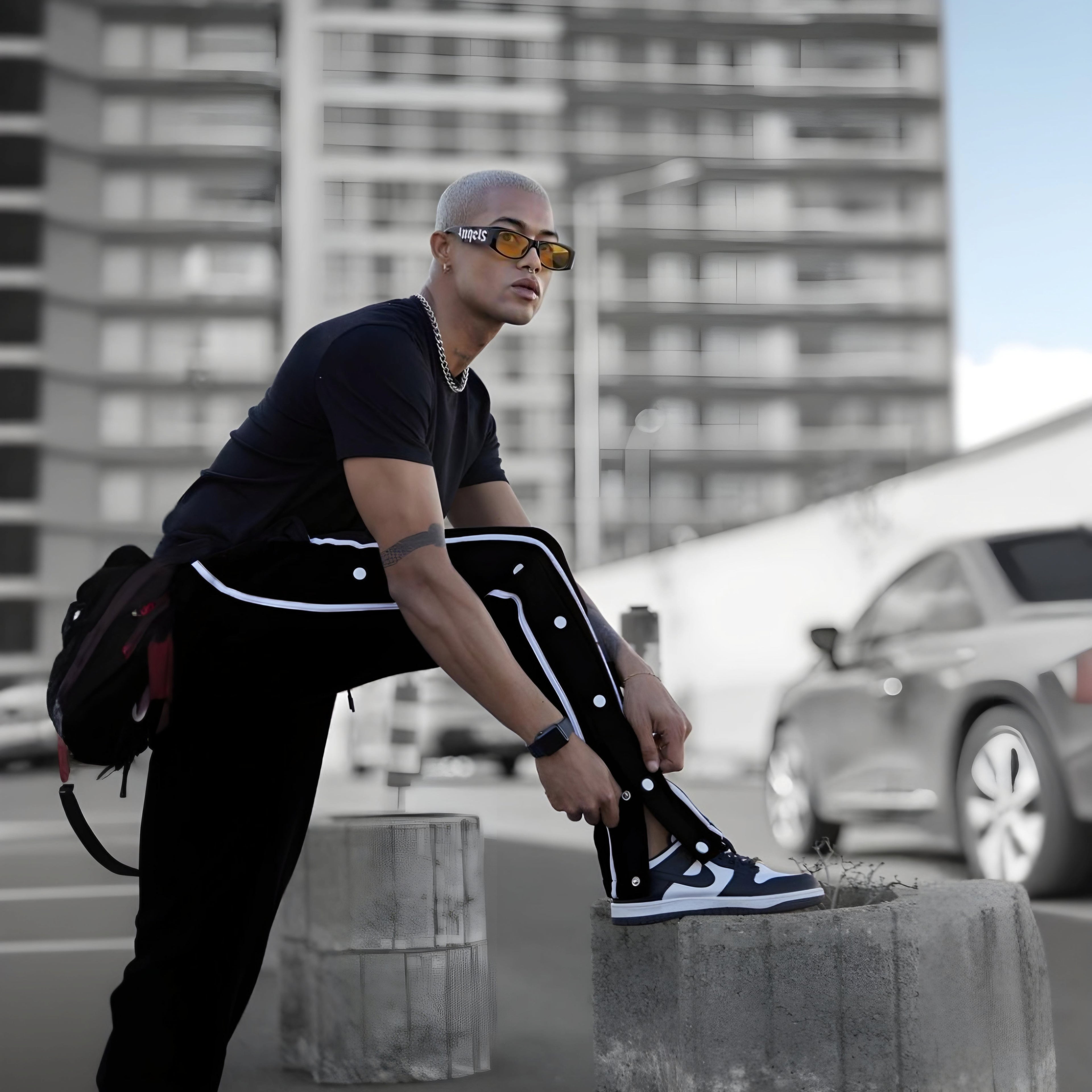 Black varsity pants with white side stripes and snap buttons - men's streetwear track pants