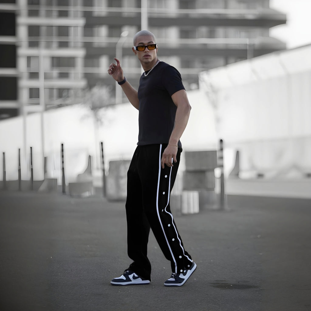 Black varsity pants with white side stripes and snap buttons - men's streetwear track pants